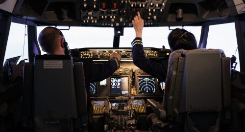 Captain and woman copilot getting ready to fly airplane and takeoff with dashboard navigation in cockpit command. Airline crew fixing altitude level and with control panel buttons, flying plane.